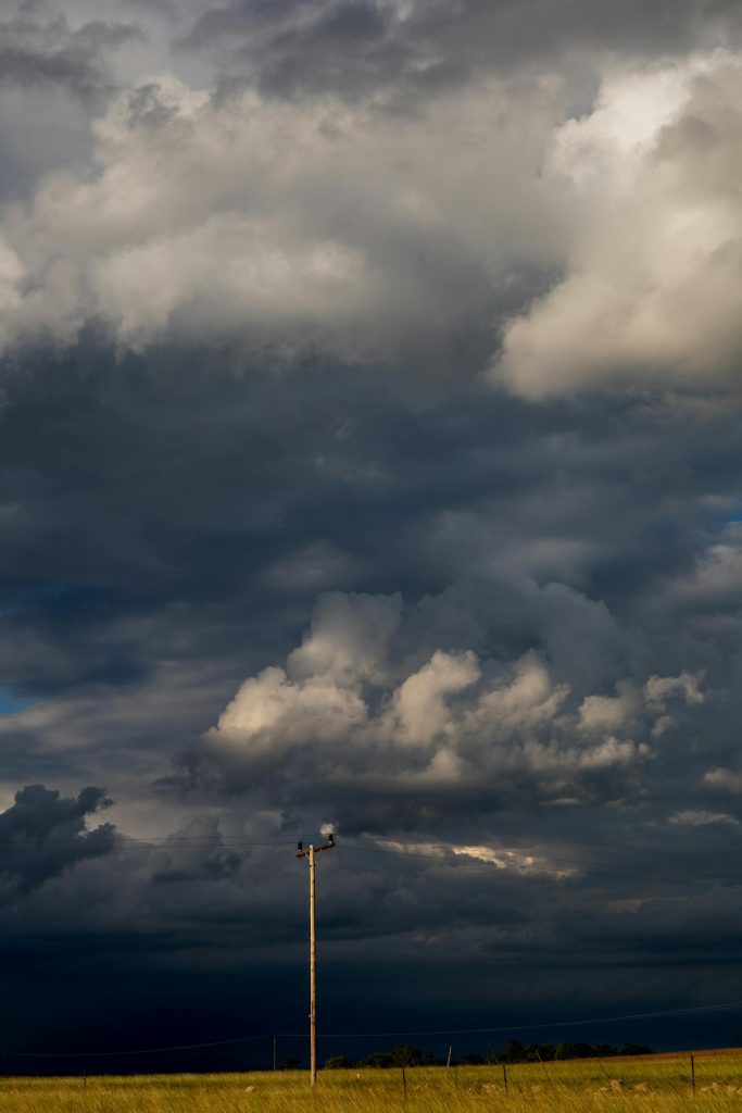 Dark storm clouds rolling over an open Texas plain with a single power line